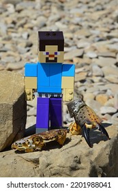 RTINA, CROATIA - 26 AUGUST, 2022: LEGO Minecraft Large Figure Of Steve Picking Up Crab (Pachygrapsus Family) Claw (also Called Pincer), Head Part Of Crab Exoskeleton Under His Legs.