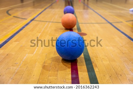 Rubber balls placed on a line on the wooden floor of a gymnasium indoor