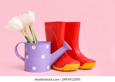 Rubber boots and watering can with tulip flowers on pink background - Powered by Shutterstock