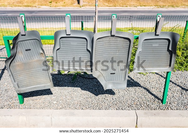 Rubber car mats hanging on the fence,\
drying after car wash. Self-service car wash,\
concept.
