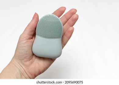 Rubber Face Wash Brush In A Woman's Hand. The Concept Of Facial Skin Care And Cosmetic Procedures.