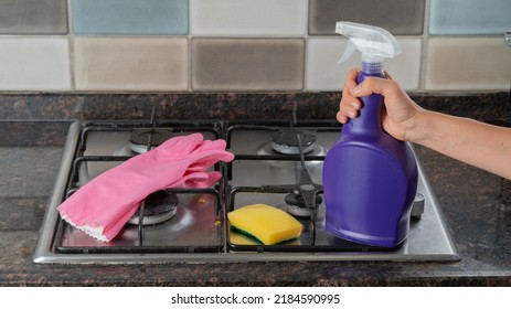 Rubber Gloves, Sponge And Hand Hold Detergent On The Gas Stove