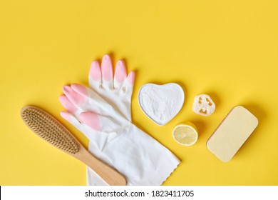 rubber gloves sponge luffa soda and wooden brush on yellow background, eco cleaning set, zero waste lifestyle concept - Powered by Shutterstock