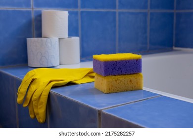 Rubber gloves and sponges inside bathroom. Closeup. Set of colorful accessory for house cleaning. Clean house. Front view.