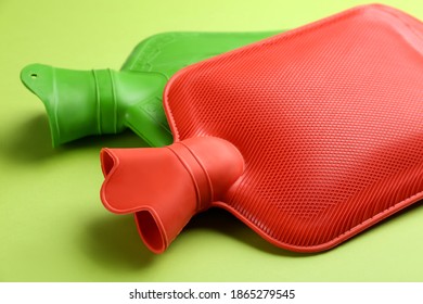 Rubber Hot Water Bottles On Green Background, Closeup