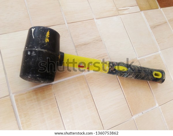 Rubber mallet isolated on\
wood