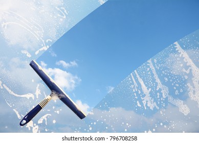 Gummipresse reinigt ein geflochtenes Fenster und reinigt einen blauen Himmelsstreifen mit Wolken, Konzept für Transparenz oder Frühlingsreinigung, Kopienraum im Hintergrund
