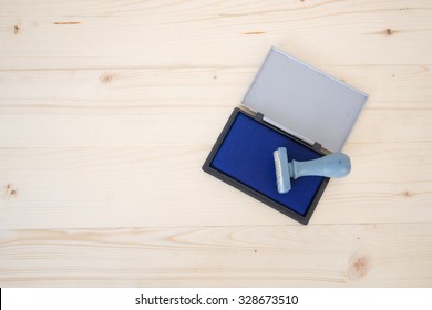 Rubber Stamp With Blue Ink Color Stamp Pad On Wood Background 