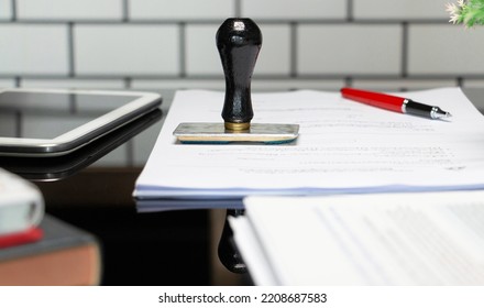rubber stamper on white paperwork with office supplies in office  - Shutterstock ID 2208687583