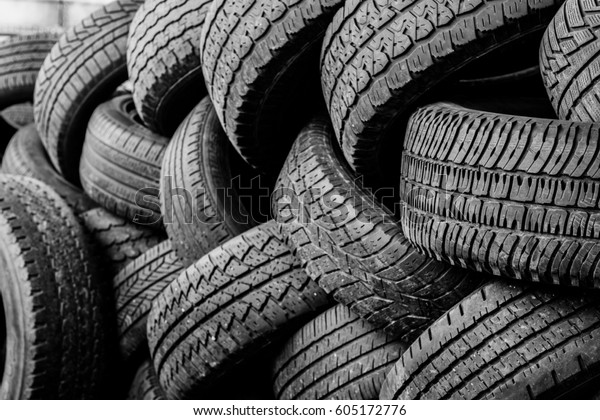 Rubber tire recycling. old used car tires \
at a junkyard in piles waiting for\
recycle.