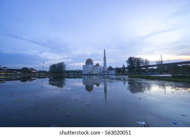 Rubbish Pollution With Plastic And Other Packaging Stuffs On The Lake With Mosque Background. Enviromental Concept.