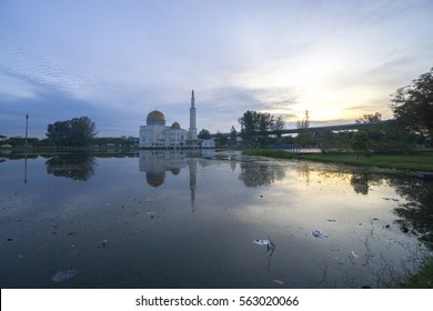 Rubbish Pollution With Plastic And Other Packaging Stuffs On The Lake With Mosque Background. Enviromental Concept.