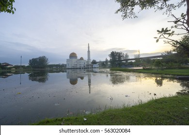 Rubbish Pollution With Plastic And Other Packaging Stuffs On The Lake With Mosque Background. Enviromental Concept.