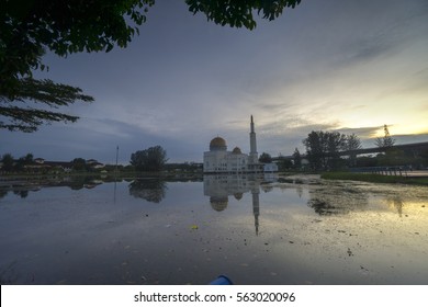 Rubbish Pollution With Plastic And Other Packaging Stuffs On The Lake With Mosque Background. Enviromental Concept.