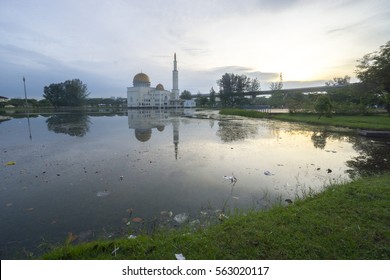 Rubbish Pollution With Plastic And Other Packaging Stuffs On The Lake With Mosque Background. Enviromental Concept.