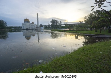 Rubbish Pollution With Plastic And Other Packaging Stuffs On The Lake With Mosque Background. Enviromental Concept.