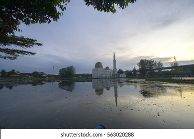 Rubbish Pollution With Plastic And Other Packaging Stuffs On The Lake With Mosque Background. Enviromental Concept.