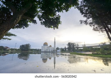 Rubbish Pollution With Plastic And Other Packaging Stuffs On The Lake With Mosque Background. Enviromental Concept.