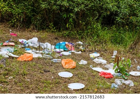 Rubbish, trash left after picnic. People illegally throw garbage into the forest. Illegal garbage dump in the nature.