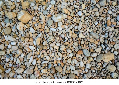 Rubble beach top view. Oceanfront structure on atlantic beach. Multicolor slag backdrop on ocean beach with natural light. Ore beach abstract. Rocky smoothness on sea bay. Stonework smoothness shore.