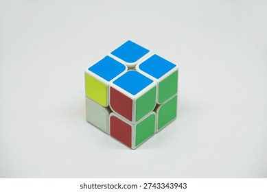 Rubik cube solver 2x2x2, also known as a pocket cube, isolated on a white background. A classic twisty puzzle toy for brain training and problem-solving.