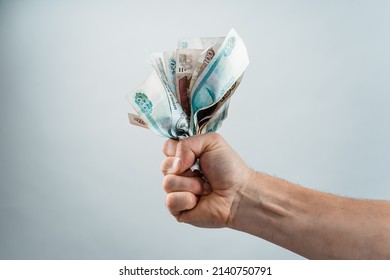 Rubles, Russian banknotes of different denominations. A wad of crumpled money in a man's fist