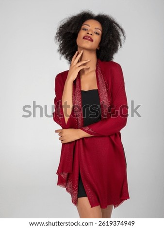 With ruby shawl aglow, she tilts her chin in defiant grace—lips bold, gaze fearless, fingertips tracing confidence. Midnight black dress anchors the sparkle, turning poise into pure modern glamour...