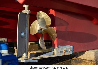 The rudder and propeller of a boat in dry dock