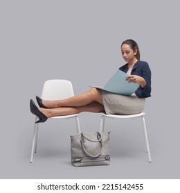 Rude Businesswoman Sitting With Feet Up In The Waiting Room And Checking Paperwork