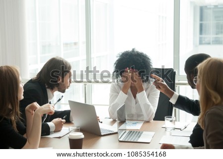 Rude diverse colleagues humiliating offending stressed upset young african woman leader suffering from gender racial discrimination during meeting or feeling exhausted tired of responsibility at work