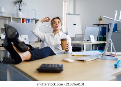 Rude female boss with a cup of coffee put her legs on the desk and throws crumpled paper at her worker - Powered by Shutterstock