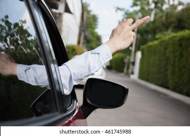 Rude And Furious Driver Giving Middle Finger To Car Behind.