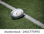 Rugby ball on lush green field, ready for action. Dynamic composition captures the essence of the game.