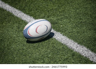 Rugby ball on lush green field, ready for action. Dynamic composition captures the essence of the game.