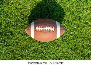 Rugby ball on a patch of grass. national sport in the United States of America. top view, - Powered by Shutterstock