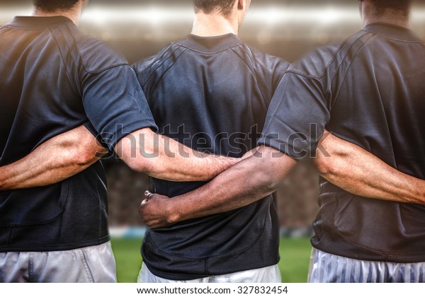 Rugby fans in arena against rugby players standing\
together before match