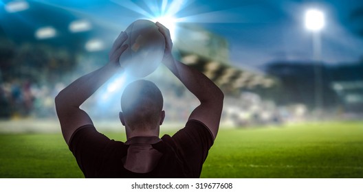 Rugby player about to throw a rugby ball against pitch and stands - Powered by Shutterstock