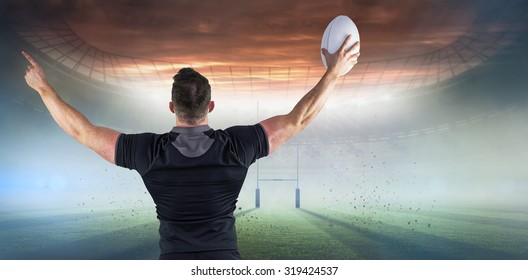 Rugby player celebrating with the ball against rugby pitch - Powered by Shutterstock