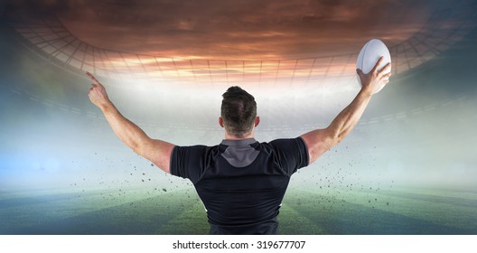 Rugby player celebrating with the ball against rugby pitch - Powered by Shutterstock