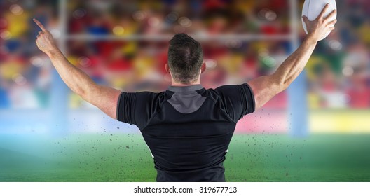 Rugby player celebrating with the ball against rugby stadium - Powered by Shutterstock