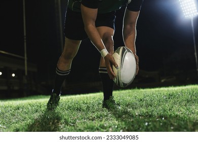 Rugby player dropping the ball to the ground for kicking as it touches the ground. - Powered by Shutterstock