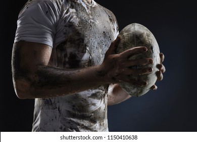 Rugby player hands with ball on dark background. Close up - Powered by Shutterstock