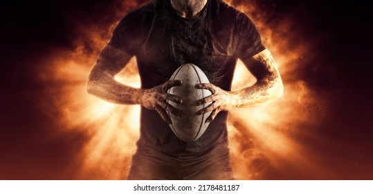 Rugby player holds ball on fire background. Sports banner. Horizontal copy space background - Powered by Shutterstock