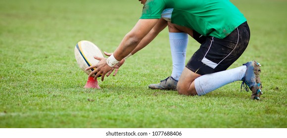 Rugby Player Preparing To Kick The Oval Ball During Game