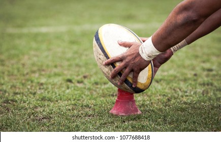 rugby player preparing to kick the oval ball during game - Shutterstock ID 1077688418