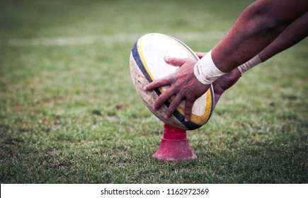 rugby player preparing to kick the oval ball during game - Shutterstock ID 1162972369