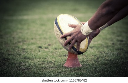 rugby player preparing to kick the oval ball during game - Shutterstock ID 1163786482