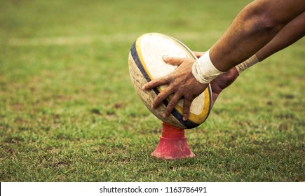 rugby player preparing to kick the oval ball during game - Shutterstock ID 1163786491