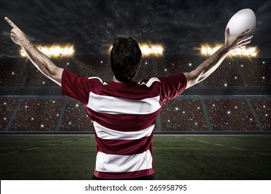 Rugby player in a red uniform celebrating on a stadium. - Powered by Shutterstock