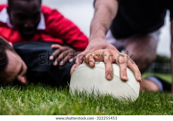 Rugby player scoring a\
try at the park